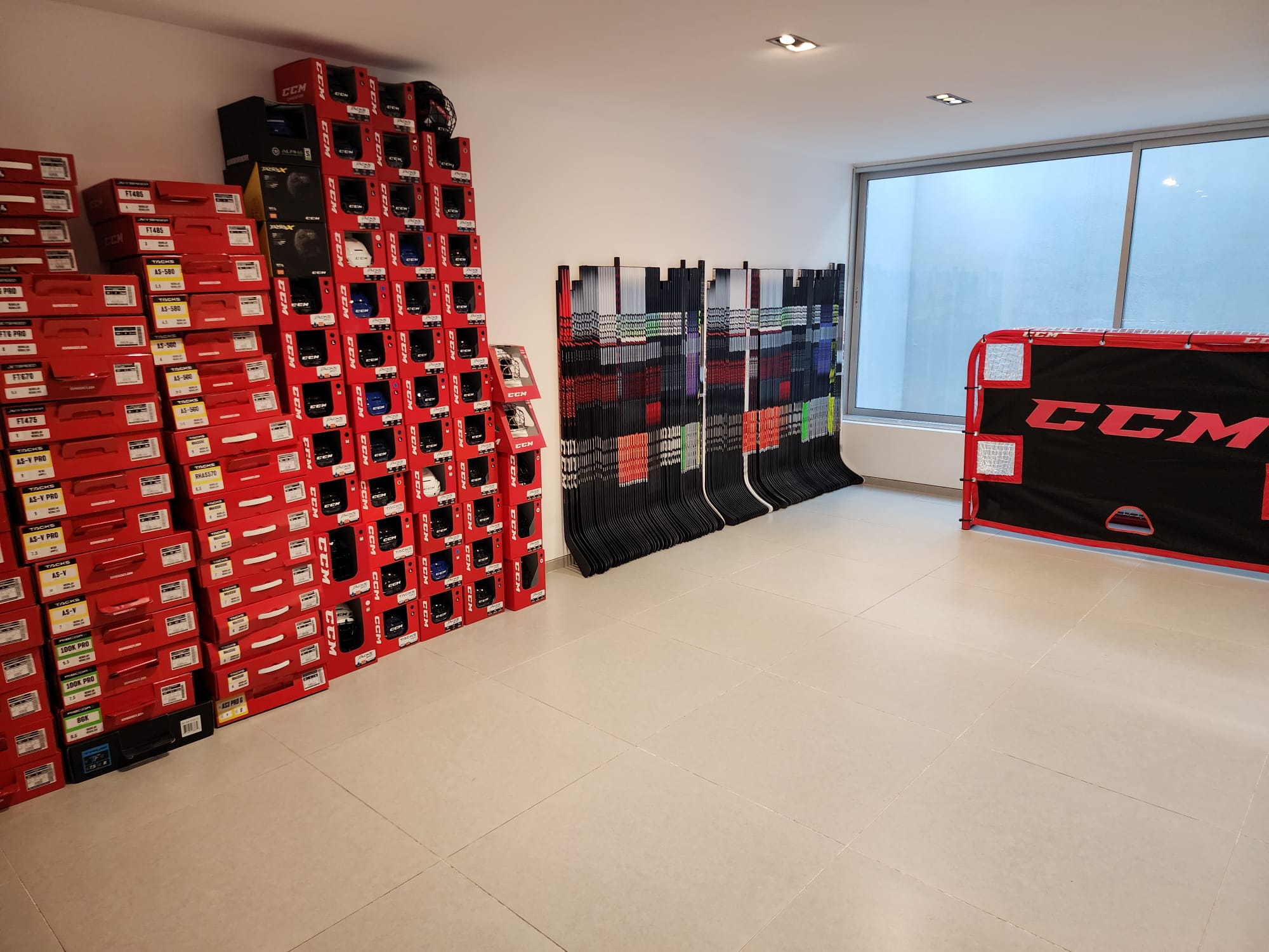 Penguin Sports showroom with skates, hockey sticks and a practice net